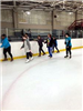 Beginner Skaters Skate Cautiously Along the Side of the Ice Rink