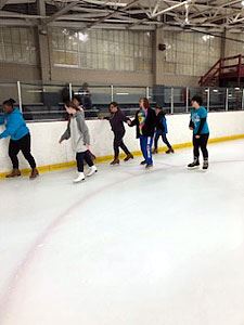 Beginner Skaters Skate Cautiously Along the Side of the Ice Rink