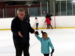 Dad and Daughter Skating on the Ice