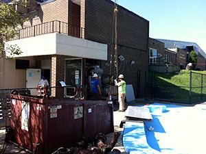 Workers Attaching Straps Onto a Compressor